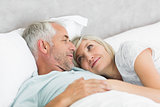 Loving mature couple lying in bed