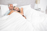 Loving mature man and woman lying in bed