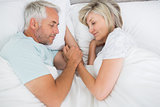 Mature couple lying in bed at home