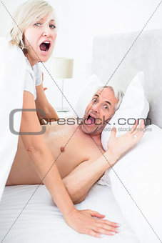 Portrait of mature couple shouting in bed