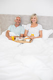 Portrait of mature couple having breakfast in bed