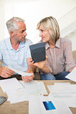 Concentrated mature couple with bills and calculator at home