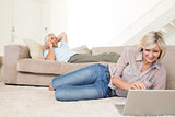 Couple with laptop and cellphone in living room at home