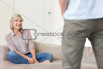 Smiling woman looking at man in living room