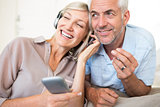 Mature couple with headphones and cellphone