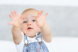 Closeup portrait of a cute baby holding out his hands