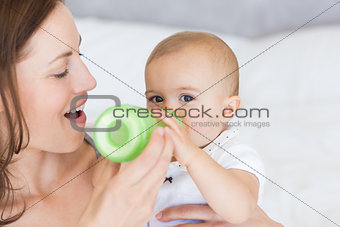 Mother feeding baby with milk bottle