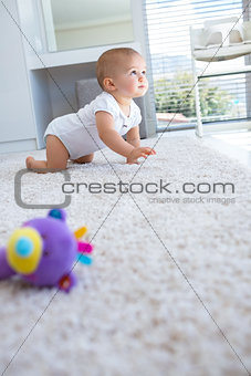 Side view of a baby crawling on carpet