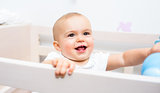 Closeup of a cheerful cute baby in the crib