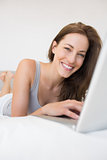 Portrait of relaxed woman using laptop in bed