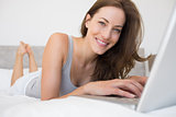 Portrait of a relaxed woman using laptop in bed