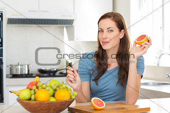 Woman with fruit bowl on counter in kitchen