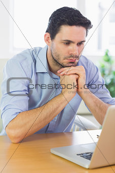 Young businessman looking at laptop