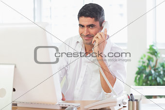 Businessman using telephone and computer