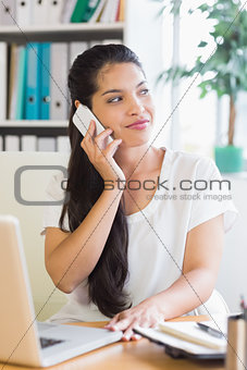 Businesswoman using mobile phone at desk