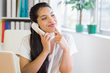 Smiling businesswoman using landline phone
