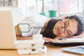 Overworked businesswoman sleeping on desk