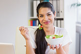 Businesswoman eating salad in office