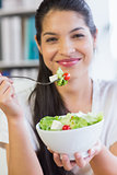 Businesswoman with salad bowl and fork