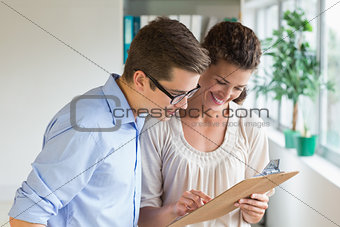 Business people discussing over clipboard