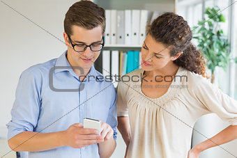 Businessman showing mobile phone to colleague