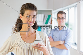 Confident businesswoman holding mobile phone