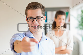 Confident businessman pointing in office