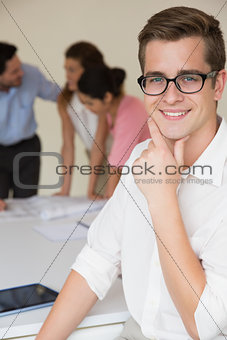 Happy businessman with hand on chin