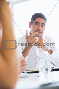 Confident businessman pointing at colleague