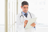 Male doctor writing on clipboard