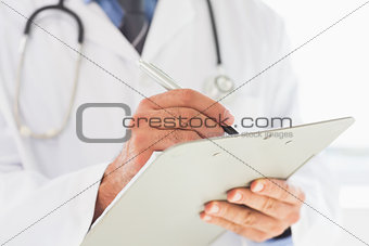 Doctor writing on clipboard