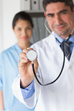 Confident doctor holding stethoscope