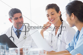 Doctors and nurse discussing over document