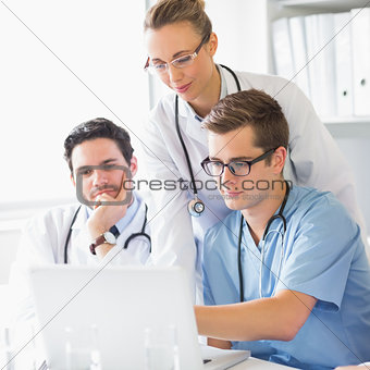 Doctors and nurse working on laptop