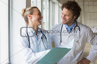 Happy doctors discussing over file