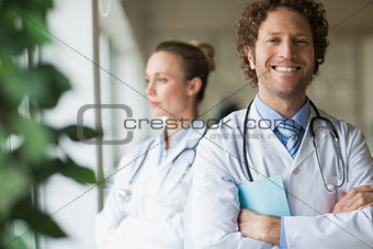 Smiling doctor standing arms crossed