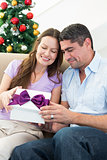 Loving couple opening Christmas gift