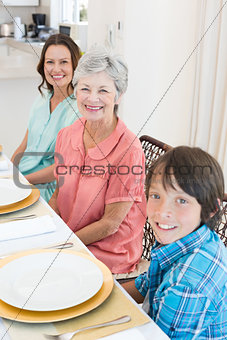 Multigeneration family sitting at dining table