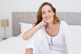 Smiling woman sitting on bed