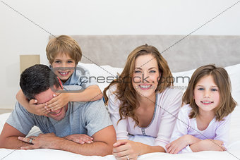 Happy family lying together in bed