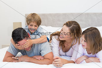 Playful boy covering fathers eyes