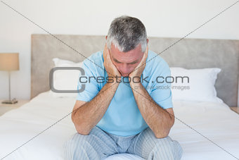 Sad senior man on bed