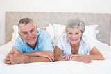 Senior couple lying in bed at home
