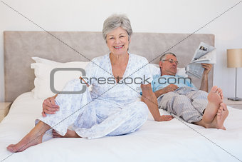Happy senior woman with man on bed