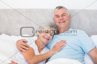 Senior man embracing woman in bed