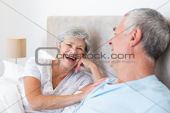 Senior woman looking at husband in bed