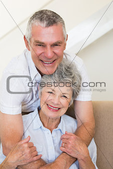 Senior man embracing wife on sofa