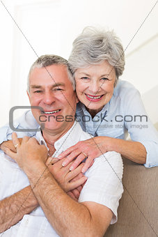 Senior woman embracing husband in house