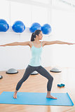 Sporty young woman stretching hands in fitness studio