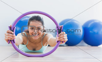 Smiling sporty woman with exercising ring in fitness studio